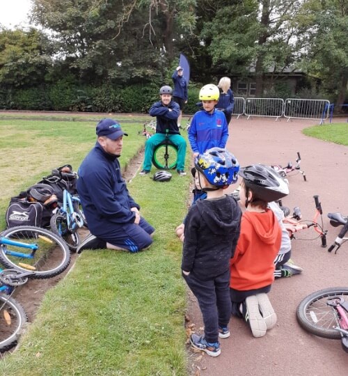 children being taught to ride unicycles