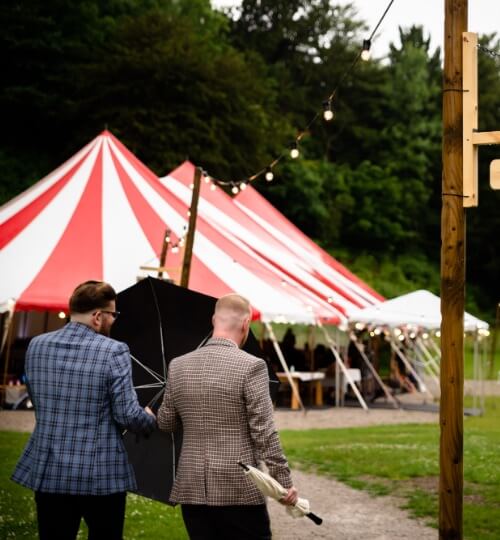 two grooms walk in the rain